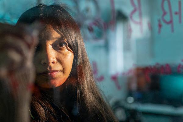 A Kent State computer science student writes equations on a board