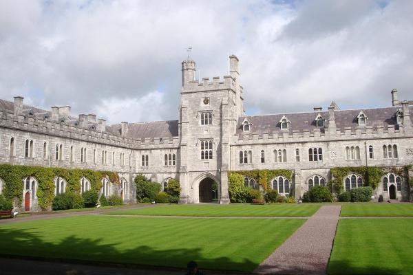University building, cloudy skies, green field.