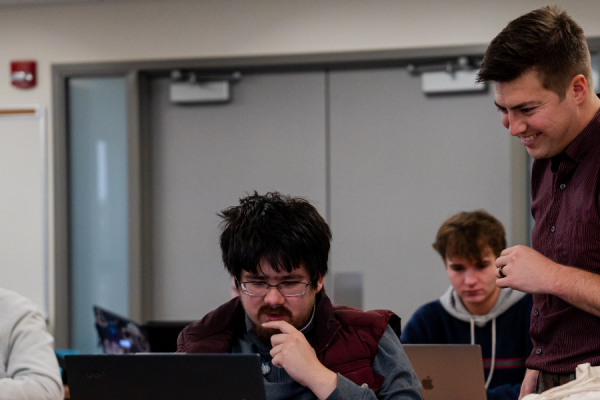 Professor working with User Experience Design student in class