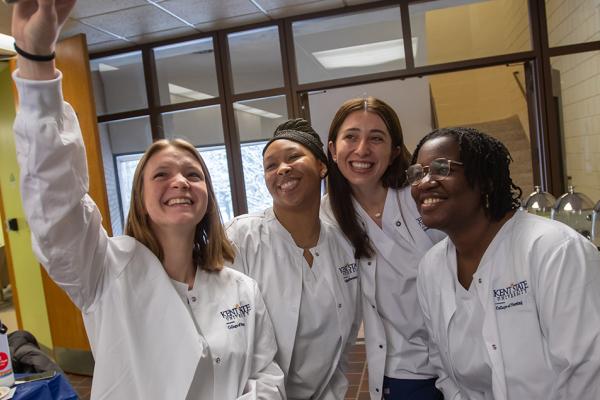 A group of young women pose for a selfie after the White Coat Ceremony.