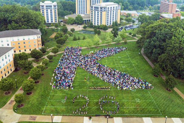 Students forming the letter "K" on campus.
