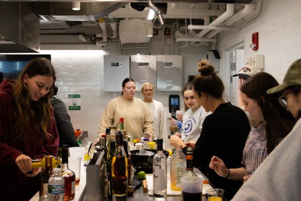 Students gathered around a counter in the Innovation Teaching Kitchen in the Design Innovation Hub.
