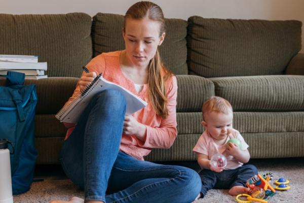 Young woman studying with baby