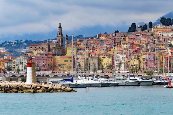 Landscape city by coast with boats, lighthouse, and colorful houses, France.