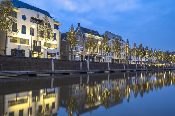 Buildings lit up at night on a river