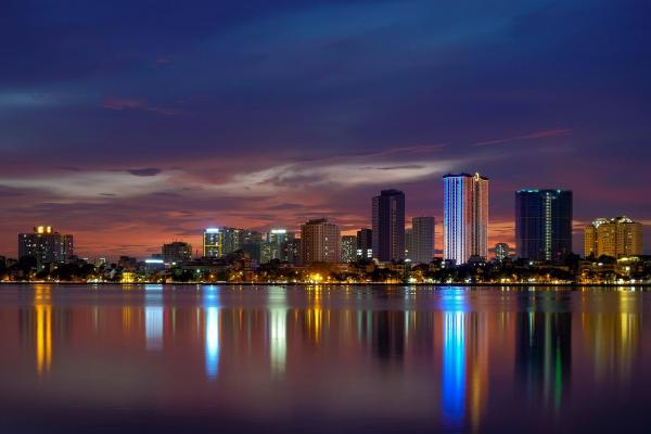 Sunset in Hanoi, Vietnam with the city on the water.