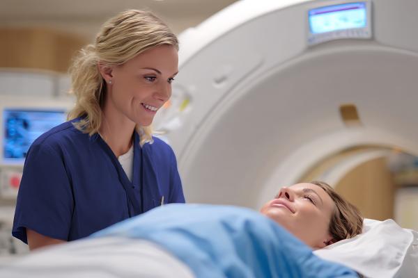 a female nurse smiles at a patient going into an mri machine