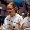 Elizabeth Pomarico helps students with indoor archery during Winterfest